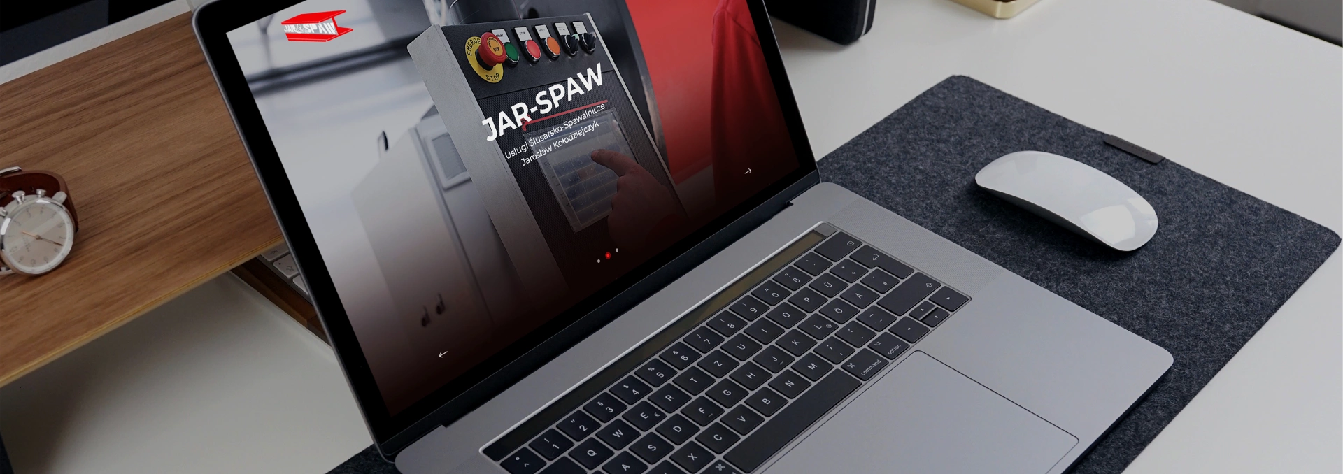 Zdjęcie przedstawia laptopa z otwartą stroną JAR-SPAW, firmy ślusarsko-spawalniczej. Na ekranie widnieje slogan „Wiedza, kwalifikacje, doświadczenie” i zdjęcie panelu sterowania.