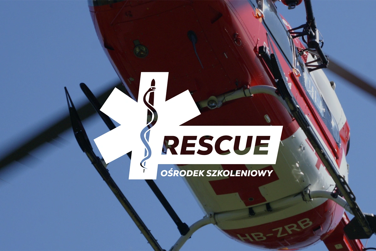 Logo "RESCUE" na tle helikoptera ratunkowego. Symbol krzyża z wężem oraz dynamiczna typografia podkreślają misję ośrodka szkoleniowego w zakresie ratownictwa i medycyny.