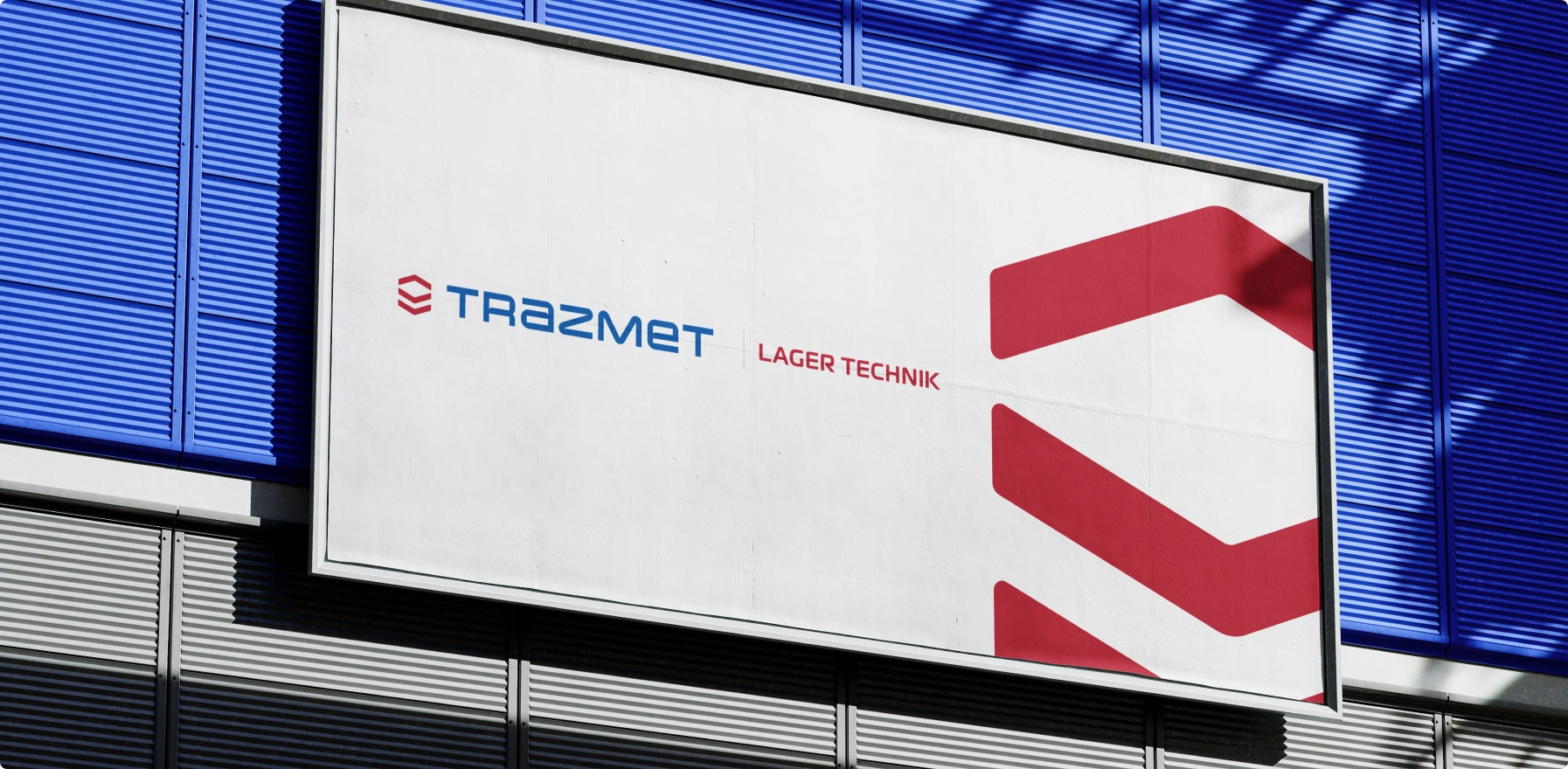 Logo firmy Trazmet Lager Technik na białej elewacji z nowoczesnym, minimalistycznym designem. Czerwone i niebieskie akcenty podkreślają dynamiczny charakter marki.
